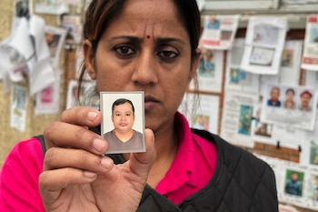 En esta imagen, tomada con un smartphone, Usha Khatri muestra una foto de su esposo, Indra Bahadur, desaparecido desde las inundaciones del mes pasado en el exterior del hospital universitario Tribhuvan, en Katmandú, Nepal, el 17 de septiembre de 2026 (AP Foto/Upendra Man Singh)