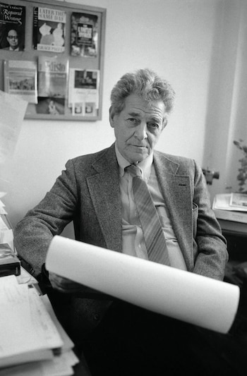 Retrato en blanco y negro de William Steig, un hombre mayor con cabello rizado gris, sentado y mirando al frente, con un tubo de papel en sus manos