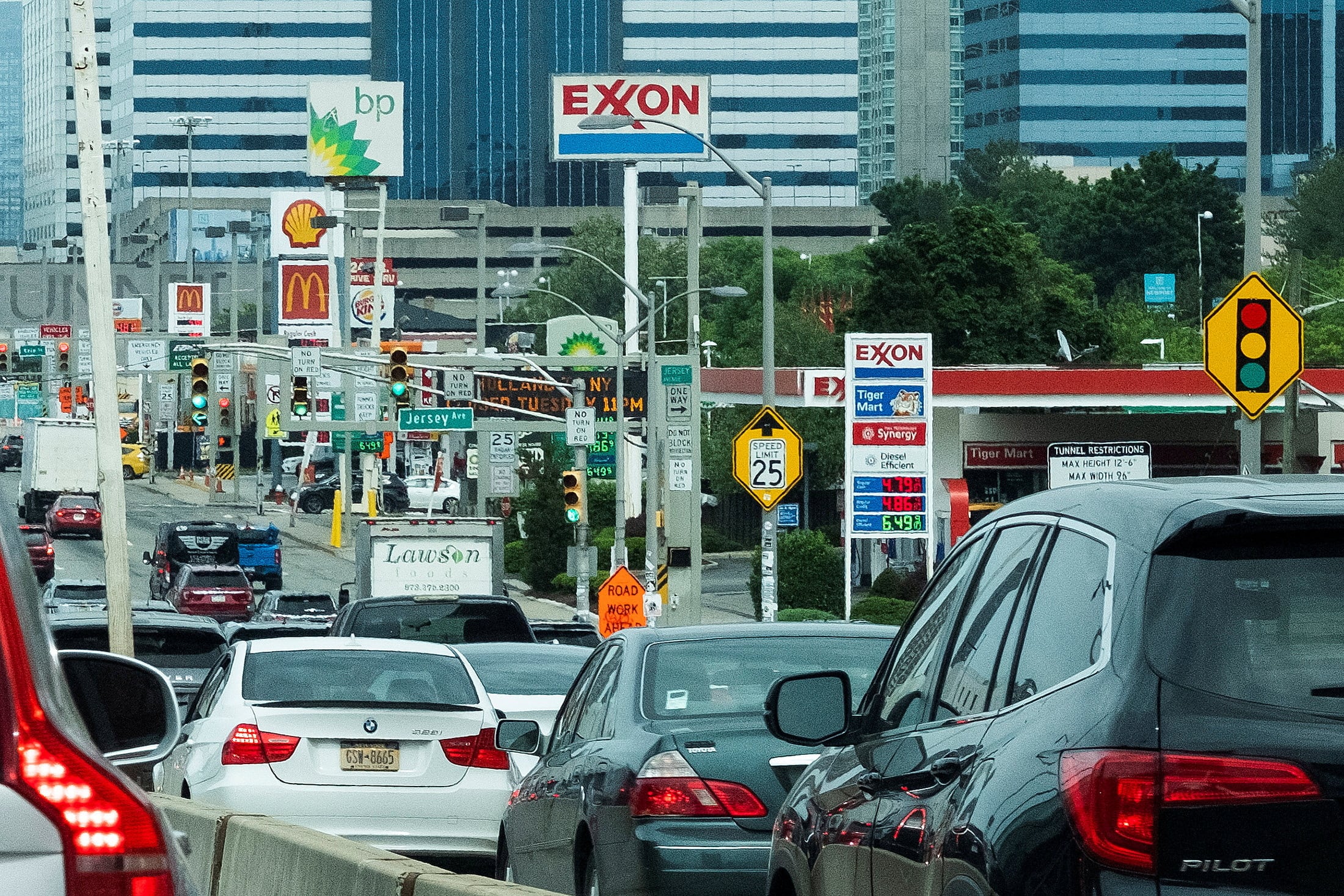 FILE PHOTO: People drive their cars near Exxon and BP gas stations at the exit of the Holland Tunnel during the start of the Memorial Day weekend, under rising gas prices and record inflation, in Newport, New Jersey, U.S., May 27, 2022. REUTERS/Eduardo Munoz/File Photo