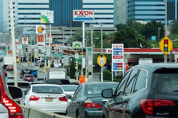FILE PHOTO: People drive their cars near Exxon and BP gas stations at the exit of the Holland Tunnel during the start of the Memorial Day weekend, under rising gas prices and record inflation, in Newport, New Jersey, U.S., May 27, 2022. REUTERS/Eduardo Munoz/File Photo