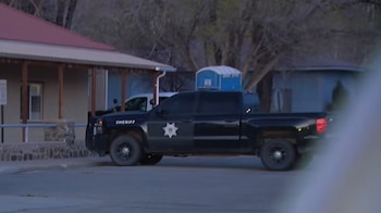 Un vehículo negro de la oficina del sheriff con el nombre "SHERIFF" y un emblema de estrella está estacionado frente a un edificio con porche
