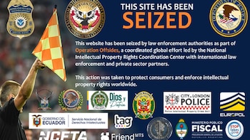 Brazo de árbitro de fútbol levantando bandera a cuadros naranja y amarillo. Fondo azul con texto 'THIS SITE HAS BEEN SEIZED' y logotipos de agencias policiales