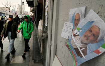 Mujeres pasan junto a carteles electorales con la imagen del ayatolá Alireza Arafi, candidato a las elecciones a la Asamblea de Expertos, en el centro de Teherán, Irán, el 21 de febrero de 2024. (AP Foto/Vahid Salemi)