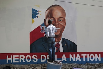 Artistas rinden homenaje a Jovenel Moïse con un retrato frente a la residencia presidencial de Puerto Príncipe donde fue asesinado, fotografiado el 7 de julio de 2023. (AP/Odelyn Joseph)