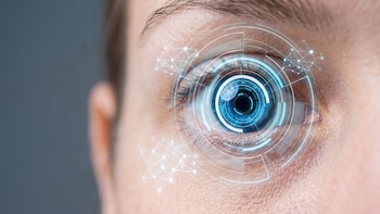 Un plano detalle de un ojo humano de iris azul con superposiciones de gráficos digitales luminosos en forma de círculos y redes