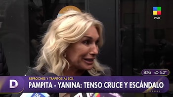 Captura de pantalla de una mujer rubia hablando frente a un micrófono, con logo de televisión, hora, temperatura y banner noticioso