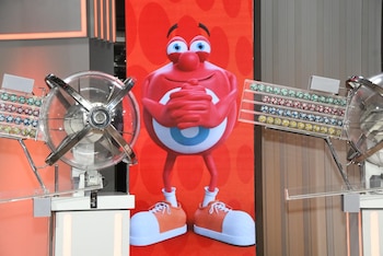 Dos conductores, dos asistentes y bolilleras en un estudio de televisión con una pantalla gigante del juego Quini 6