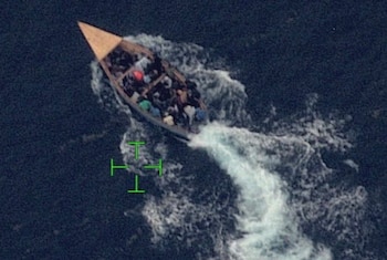 Vista aérea de una embarcación sobrecargada con migrantes en aguas del Canal de la Mona, entre República Dominicana y Puerto Rico (Cortesía: @USCGSoutheast).