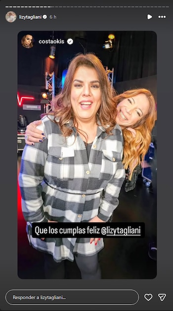 Dos mujeres sonríen ante la cámara en un estudio de televisión, una vista con camisa a cuadros y la otra apoyada en su hombro