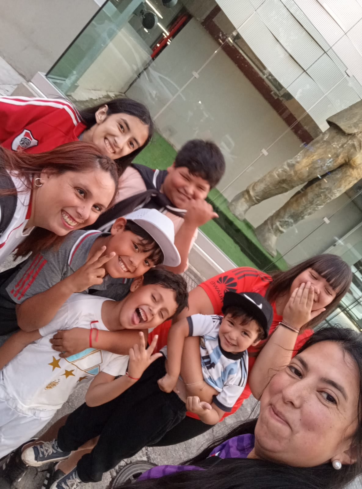 Delfina y su familia frente a la estatua de Marcelo Gallardo