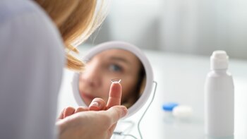 Una mujer colocándose una lentilla