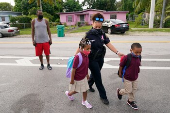 Una oficial acompaña a dos