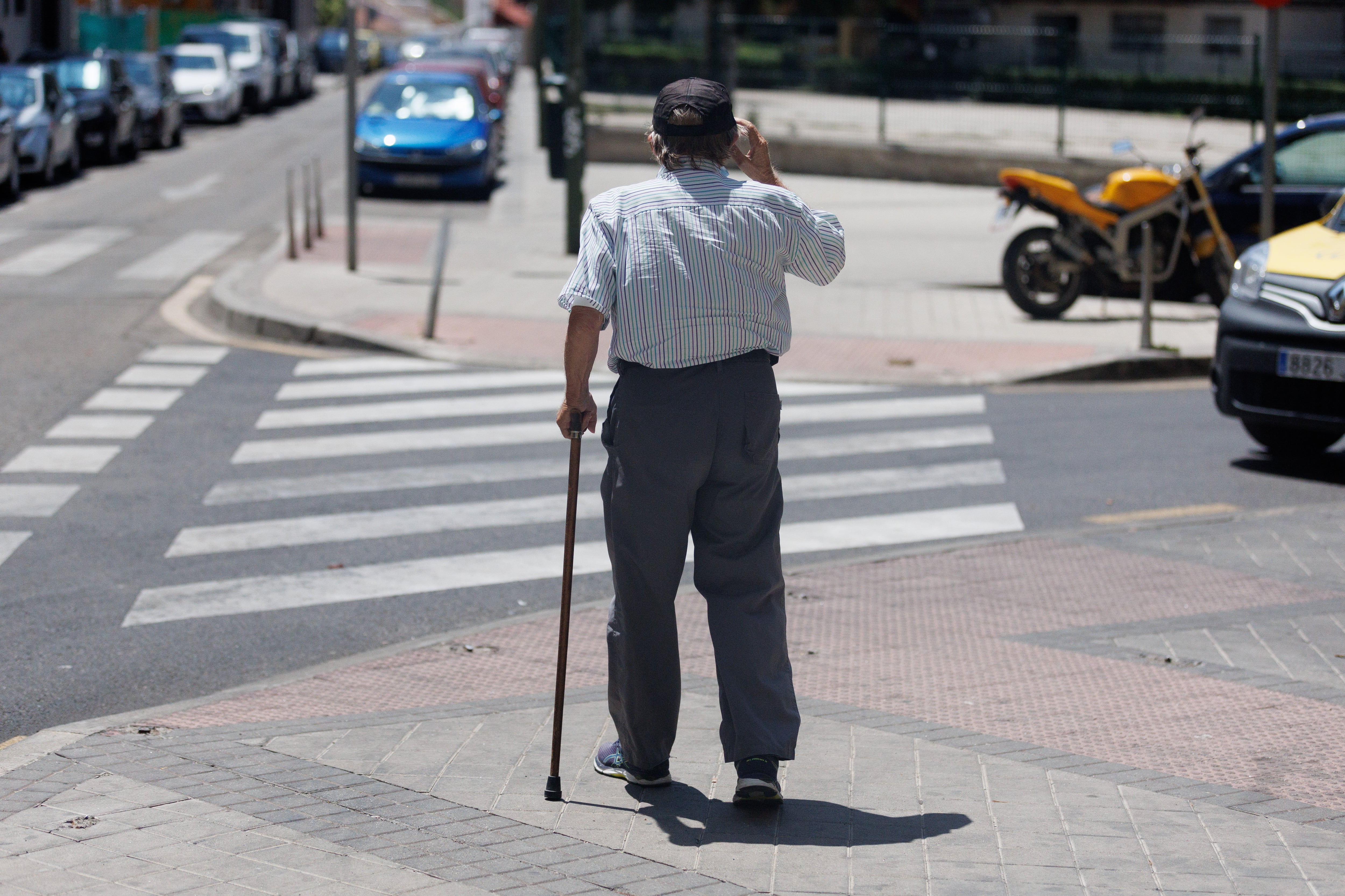 Un hombre mayor pasea apoyándose en un bastón, a 24 de julio de 2023, en Madrid. (Eduardo Parra / Europa Press)