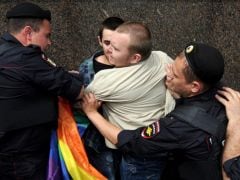 Policías antidisturbios rusos detienen a un activista por los derechos LGTBI durante una manifestación no autorizada en el centro de Moscú, en medio de la represión sostenida contra este colectivo en Rusia, el 25 de mayo de 2013. (AFP/Andrey Smirnov)