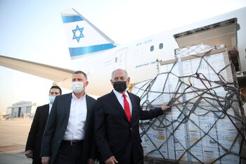 El primer ministro Benjamin Netanyahu y su ministro de Salud Yuli Edelstein reciben un cargamento de vacunas de Pfizer-BioNTech (Motti Millrod/Pool via REUTERS/Archivo)