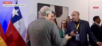 José Antonio Kast de espaldas conversa con Fernando Cerimedo frente a una bandera de Chile en una transmisión en vivo