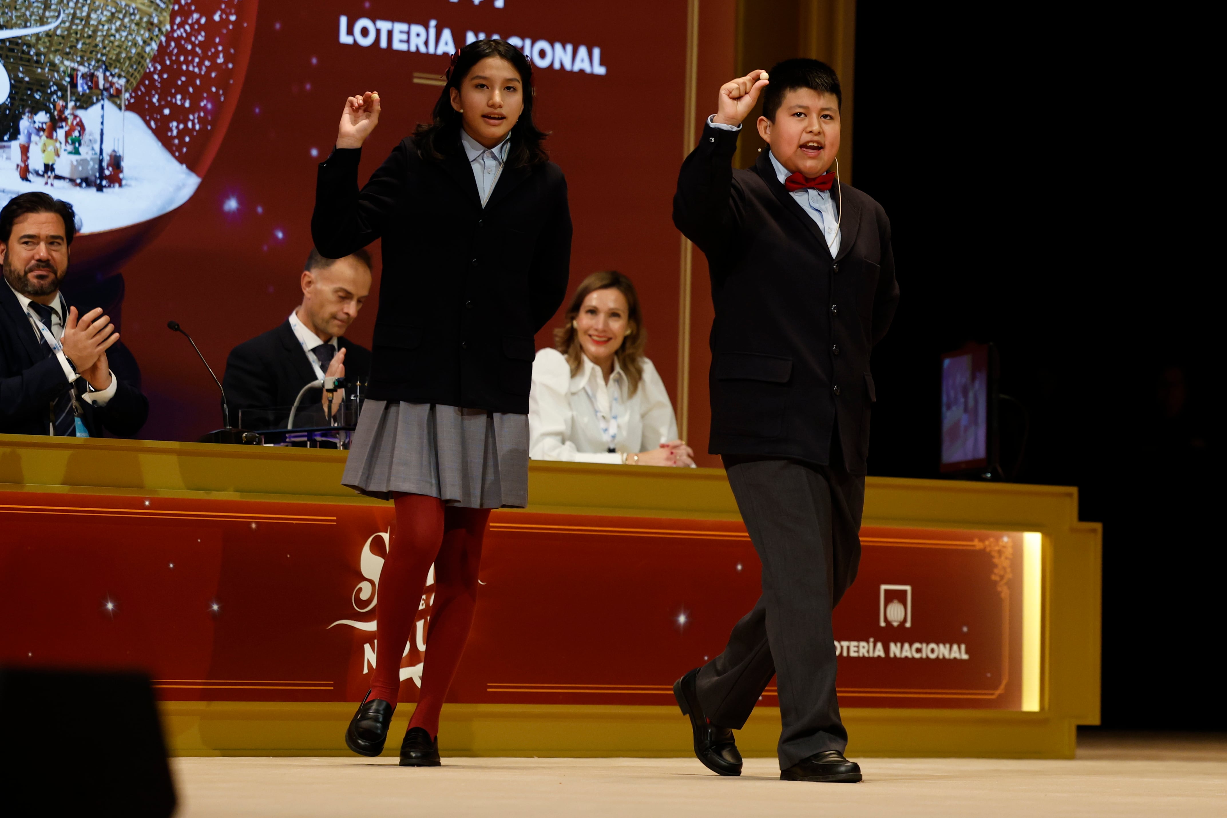 Aisha Solange (i) y Gorka Calderón (d), cantan un cuarto premio, el 78.477, que ha sido agraciado con un cuarto premio en el Sorteo de la Lotería de Navidad y dotado con 200.000 euros a la serie (20.000 euros al décimo). (EFE/Chema Moya)