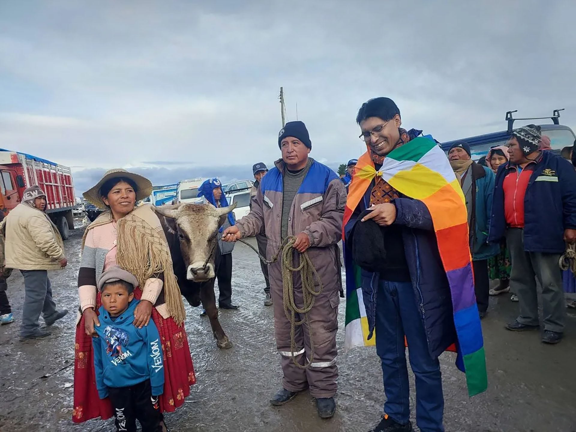 El senador suplente boliviano Nilton Condori viste una bandera wiphala y posa junto a pobladores y un toro que vendió para financiar un viaje por el país.