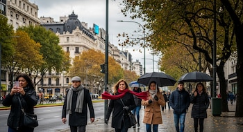 Em primeiro plano estão várias pessoas abrigadas caminhando por uma rua arborizada em Buenos Aires com edifícios ao fundo; alguns carregam guarda-chuvas.
