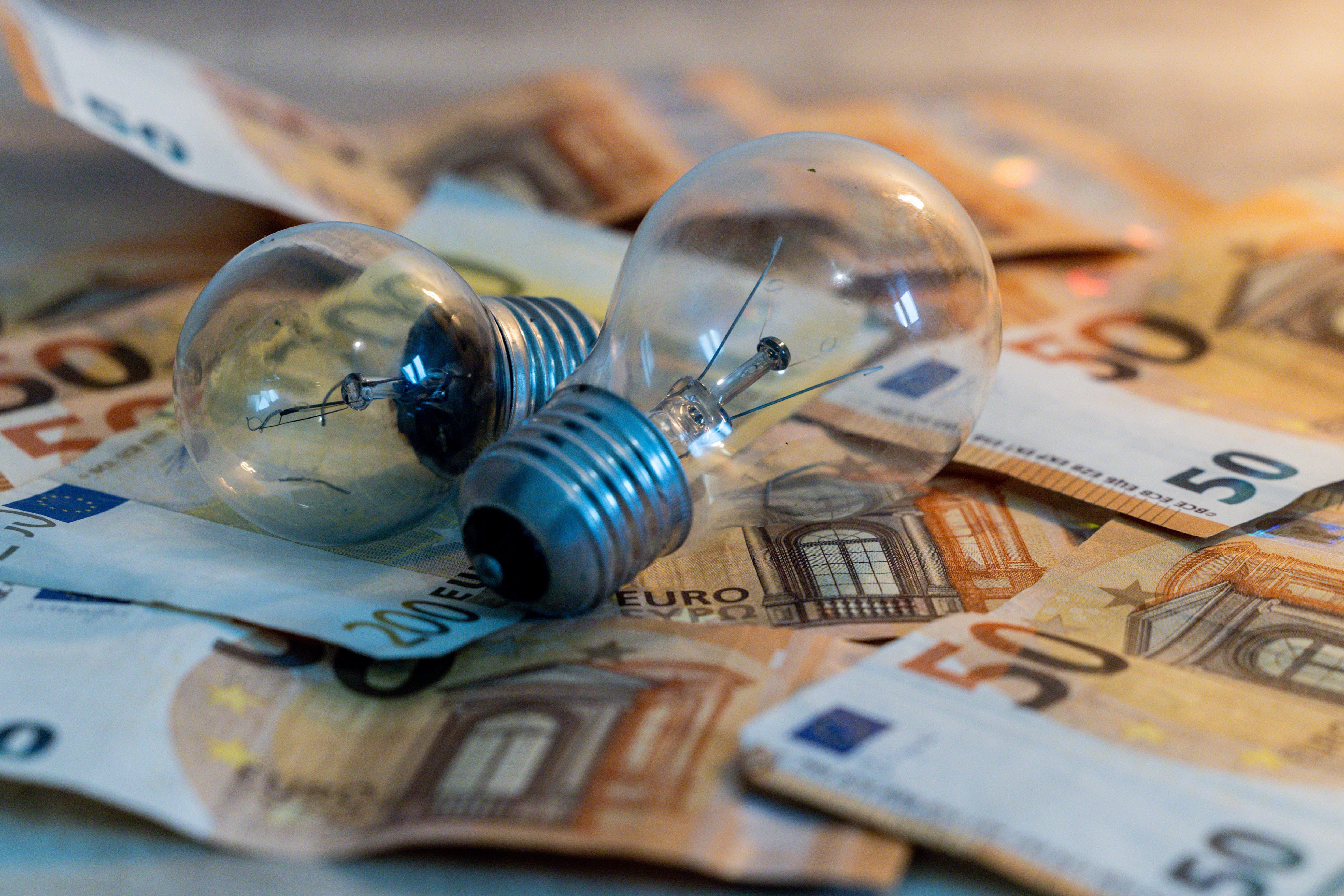 Dos bombillas sobre billetes de 50 euros. (Ricardo Rubio/Europa Press)