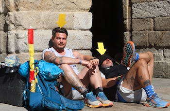 Dos peregrinos italianos descansan este viernes en la Plaza del Obradoiro, en Santiago de Compostela. Las temperaturas iniciarán este viernes un ascenso que dejará calor intenso en casi toda España y que podría derivar, a partir del domingo, en una ola de calor en la península y Baleares, con noches muy cálidas y máximas que podrán superar los 42 grados. EFE/ Xoán Rey