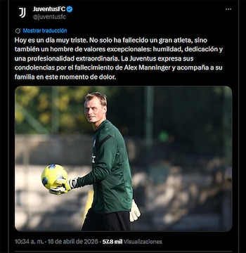 Primer plano de un hombre rubio con camiseta verde y guantes blancos, sosteniendo un balón de fútbol amarillo y azul con ambas manos, mirando al frente