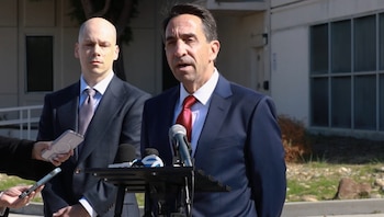 Jeff Rosen habla ante varios micrófonos y teléfonos móviles en el exterior de un edificio junto a otro hombre trajeado
