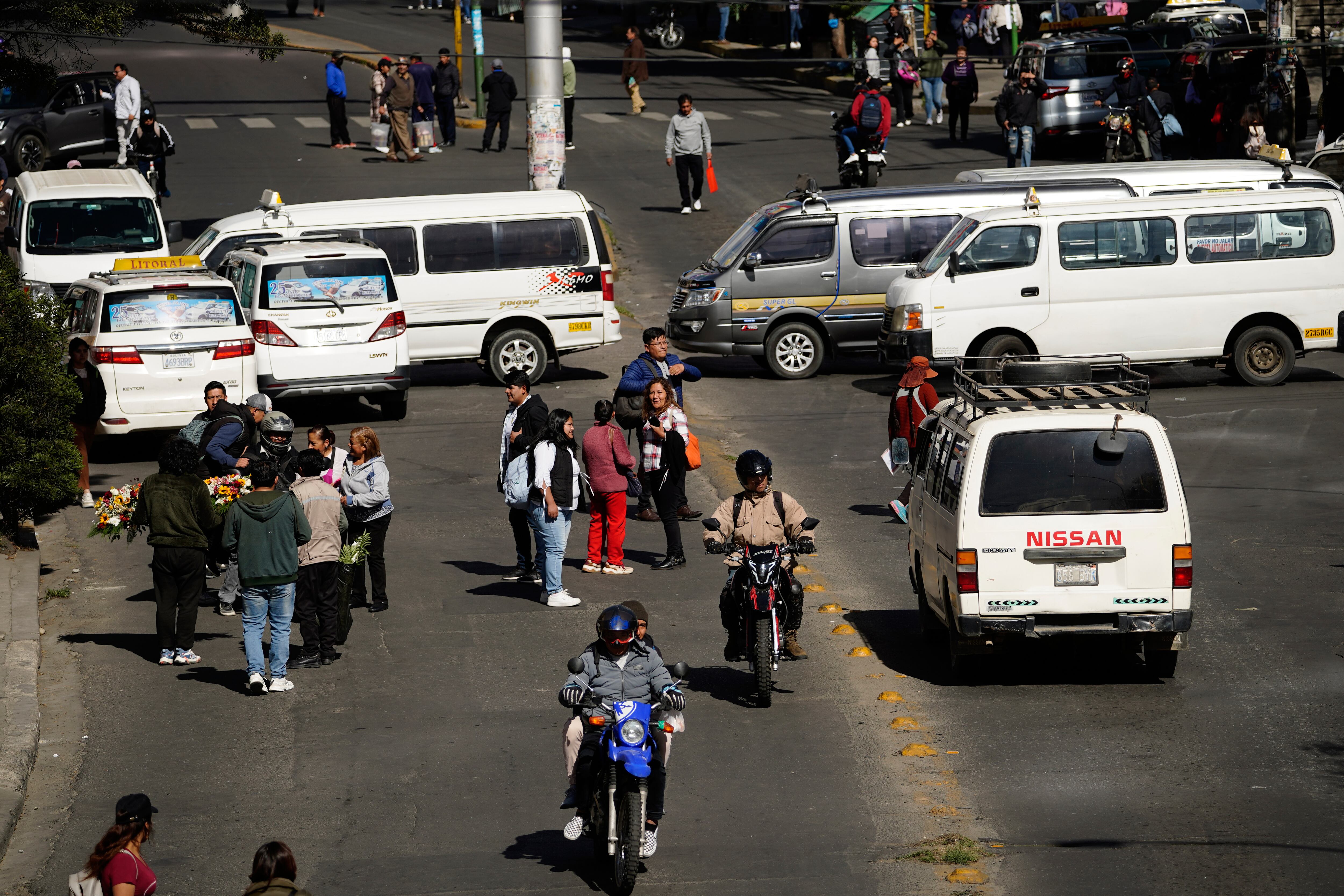 La gente camina durante la huelga del sector del transporte público en La Paz, Bolivia, el viernes 19 de diciembre de 2025, después de que el presidente Rodrigo Paz anunciara el fin de los subsidios al combustible. (AP Foto/Freddy Barragan)