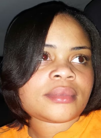 Primer plano del rostro de una mujer de cabello oscuro corto y camiseta naranja que mira hacia un costado