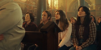 Varias personas sentadas en los bancos de madera en el interior de una iglesia