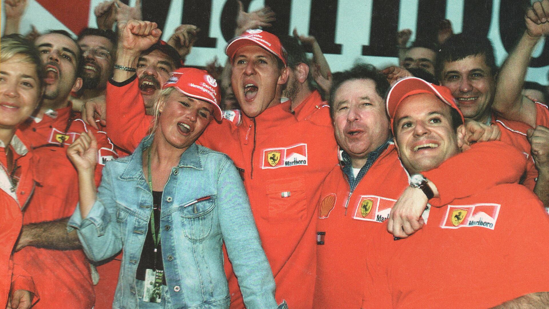 Día histórico: 8/10/2000. Festejos por el primer título de Michael Schumacher. Fue tras ganar en Japón. El Kaiser celebra junto a su mujer, Corinna. A la izquierda del alemán, Jean Todt y el otro piloto de la Scuderia, Rubens Barrichello (Archivo CORSA).