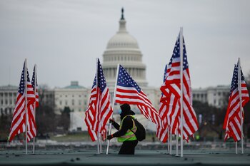 Un trabajador instala una bandera
