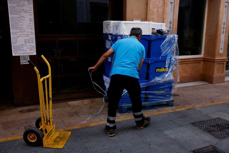 Un repartidor desempaqueta cajas. (REUTERS/Jon Nazca)