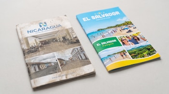 Dos folletos turísticos, uno de Nicaragua sucio con imágenes de hoteles vacíos, y otro de El Salvador limpio con fotos de playas y turistas, sobre fondo claro.