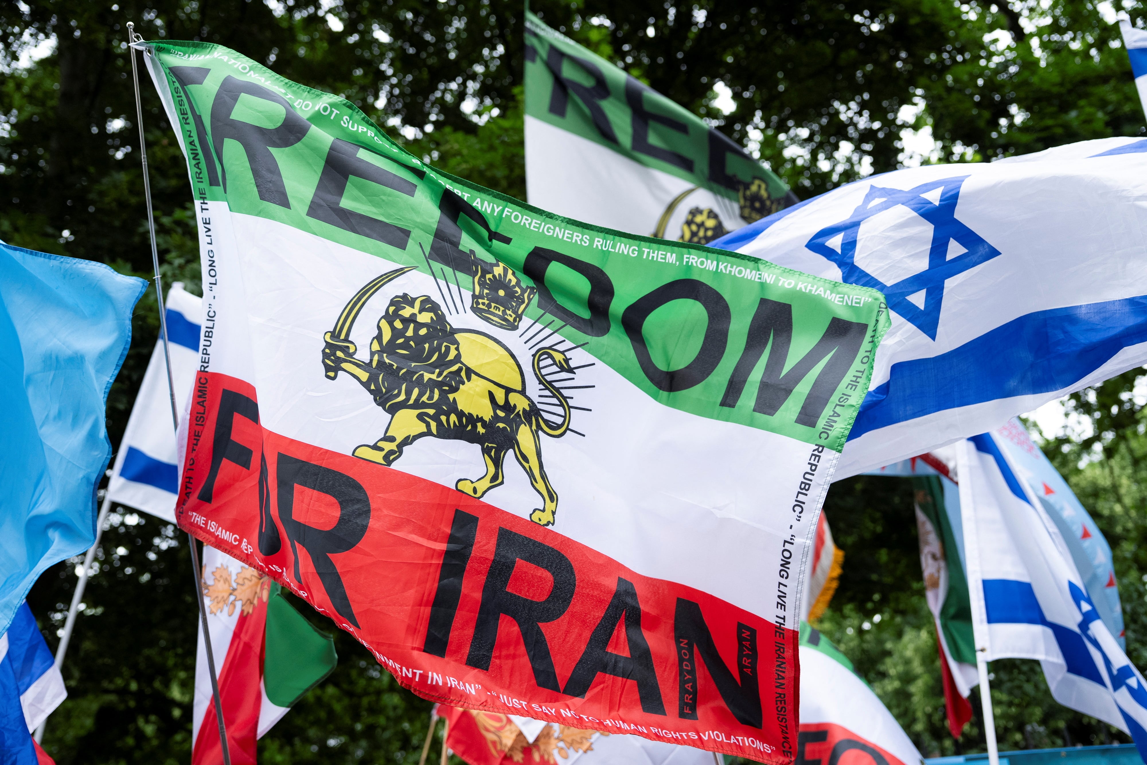 Se exhiben banderas mientras partidarios del príncipe heredero exiliado de Irán, Reza Pahlavi, y manifestantes proisraelíes se reúnen frente a la embajada de Irán durante una protesta en Londres (REUTERS/Carlos Jasso)