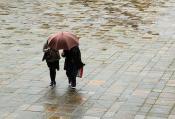 Turistas bajo la lluvia en