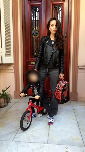 En zapatillas y chaqueta de