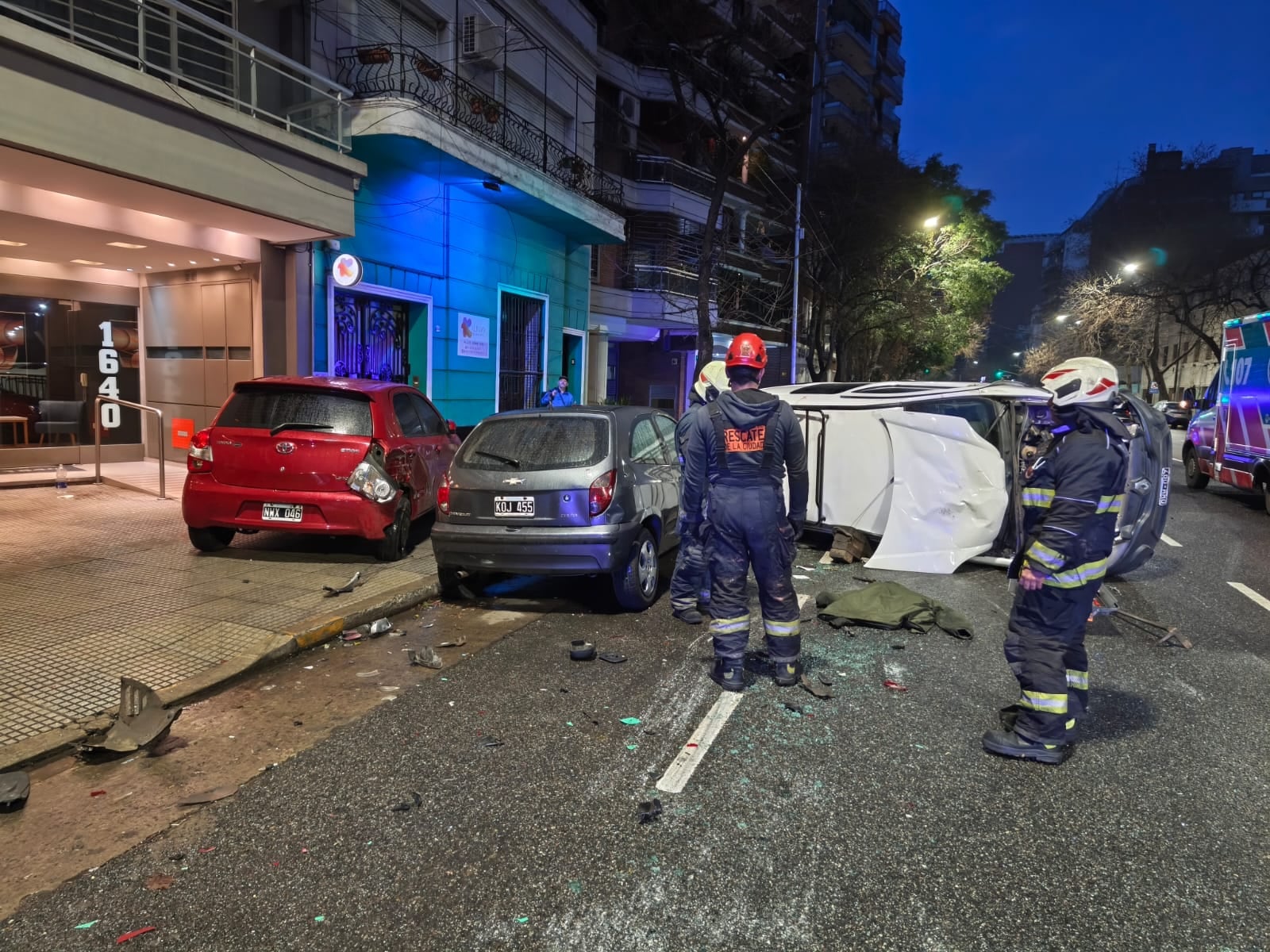 Personal de rescate atiende un siniestro vial que involucra a tres vehículos, uno de ellos volcado en una calle de la ciudad.