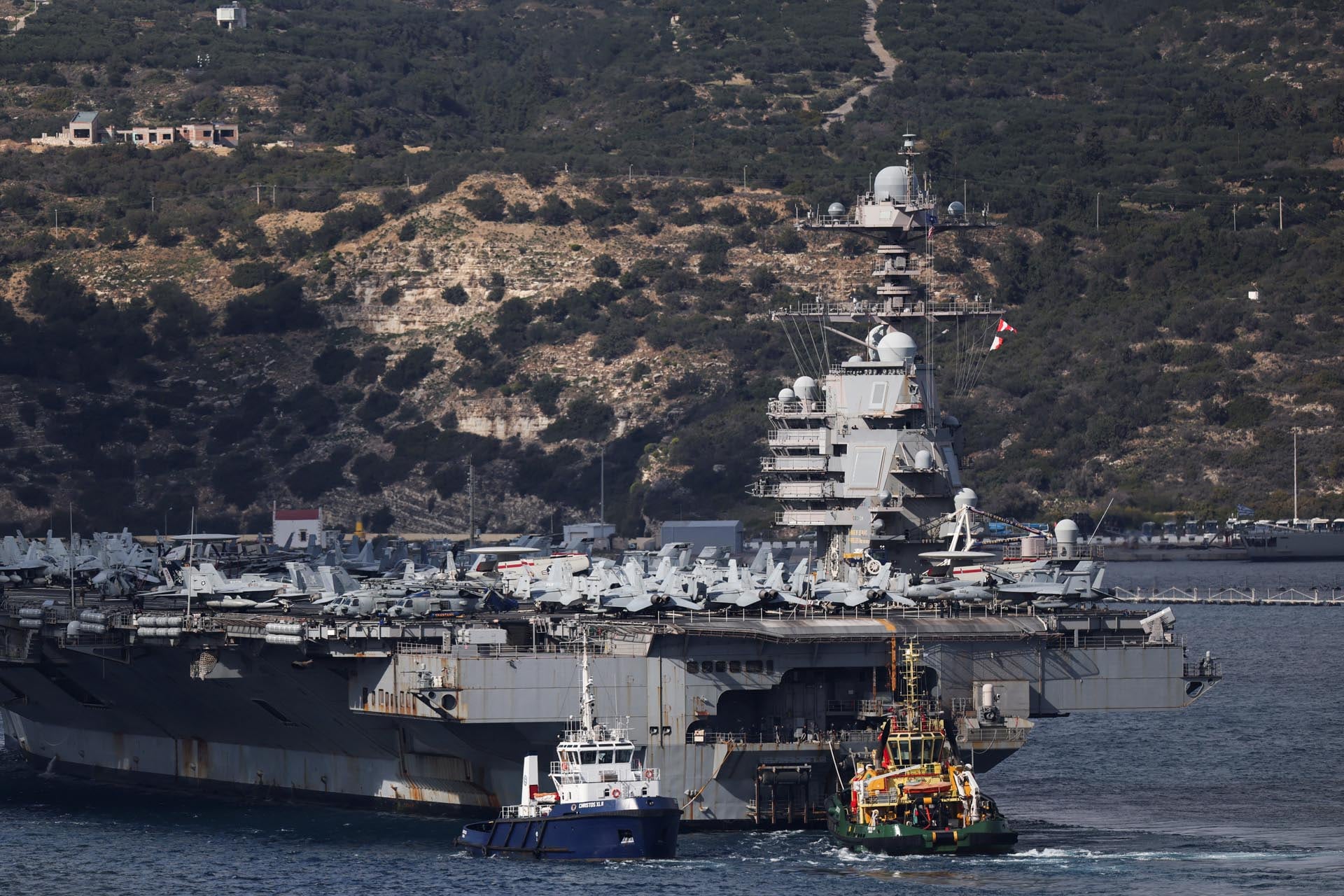 El portaaviones de la Armada de EE.UU. USS Gerald R. Ford llega a la Bahía de Souda en la isla de Creta, asistido por remolcadores. (Reuters)