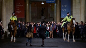Espectadores y policías montados participan