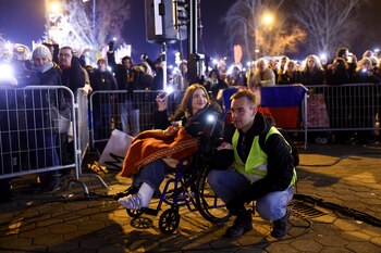 Gente sostiene sus celulares durante un minuto de silencio mientras bloquean un puente durante una protesta por el derrumbe de una cornisa de concreto que mató a varias personas hace más de dos meses en Novi Sad, Serbia, el domingo 2 de febrero de 2025 (AP Foto/Armin Durgut)