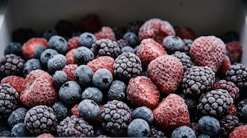 Arándanos, frutillas y moras congeladas con escarcha y partículas de hielo.