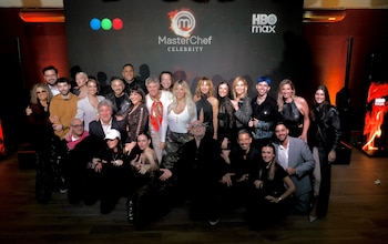 Un grupo de personas posa frente a un fondo negro con logotipos de MasterChef Celebrity, Telefe y HBO Max