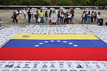 Personas sostienen carteles con imágenes