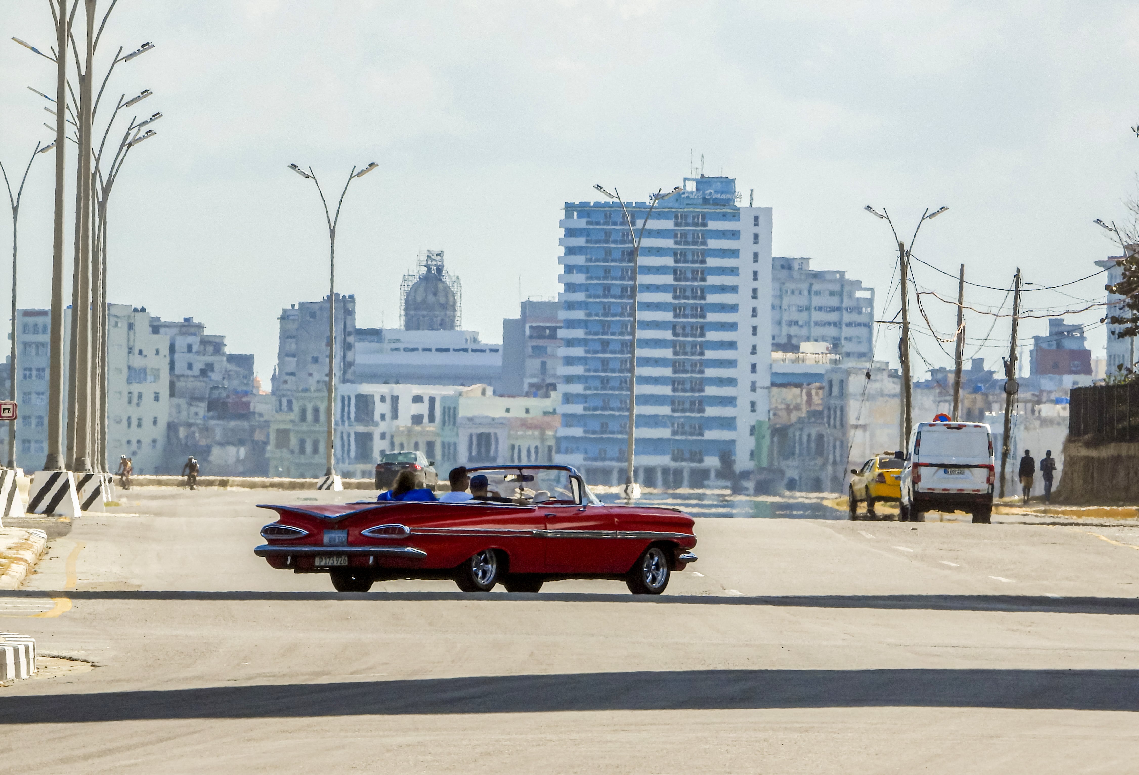 Turistas viajan en un viejo automóvil estadounidense usado como taxi por una tranquila avenida de La Habana el 8 de febrero de 2026. El gobierno cubano anunció el 6 de febrero medidas de emergencia para hacer frente a una grave crisis energética agravada por las sanciones estadounidenses, incluyendo la adopción de una semana laboral de cuatro días para las empresas estatales y restricciones a la venta de combustible. (Foto de ADALBERTO ROQUE / AFP)