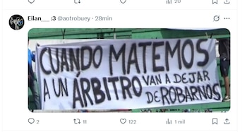 Primer plano de una pancarta blanca sostenida por personas, con el texto en mayúsculas negras que dice: 'CUANDO MATEMOS A UN ÁRBITRO VAN A DEJAR DE ROBARNOS'