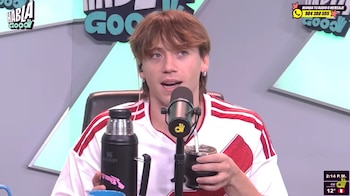 Paulo Londra frente a un micrófono sosteniendo un recipiente de mate y un termo negro durante una entrevista en un estudio