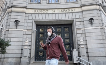FILE PHOTO: A man wears a protective face mask as he walks past Banco de Espana (Bank of Spain), amidst concerns over coronavirus outbreak, in Barcelona, Spain March 14, 2020. REUTERS/Nacho Doce/File Photo