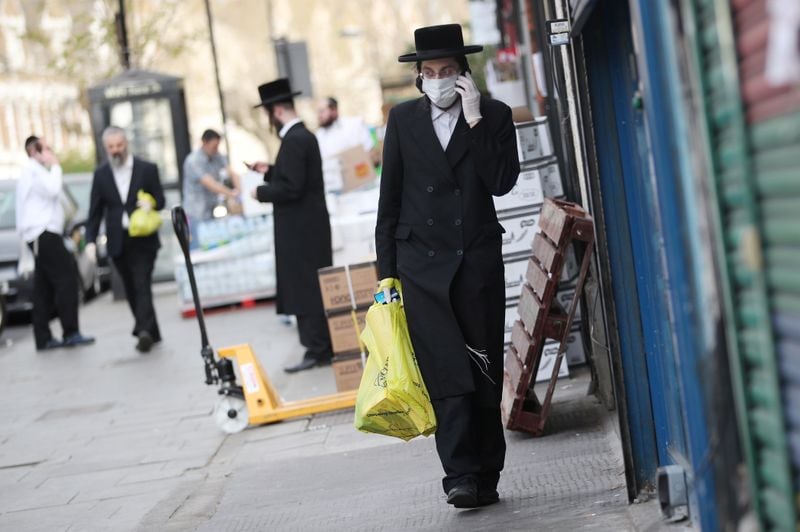 Imagen de un judío ortodoxo con mascarilla andando por una calle de Londres, Reino Unido. 8 abril 2020. REUTERS/Hannah McKay