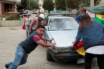 Activistas de la resistencia civil detienen un vehículo en la entrada de la Urbanización La Rinconada, donde se ubica la residencia del embajador mexicano, en La Paz, Bolivia, (Reuters: Manuel Claure)